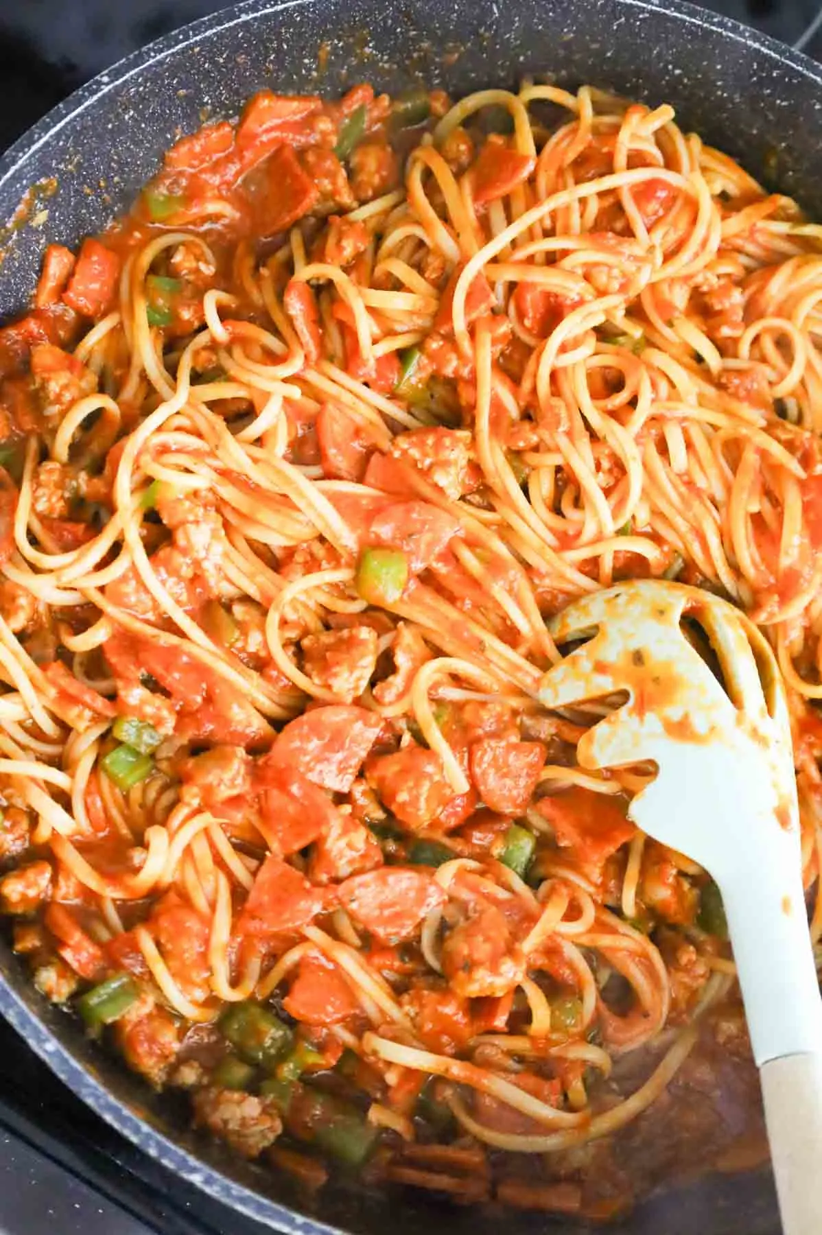 pepperoni, green pepper and sausage spaghetti mixture in a skillet