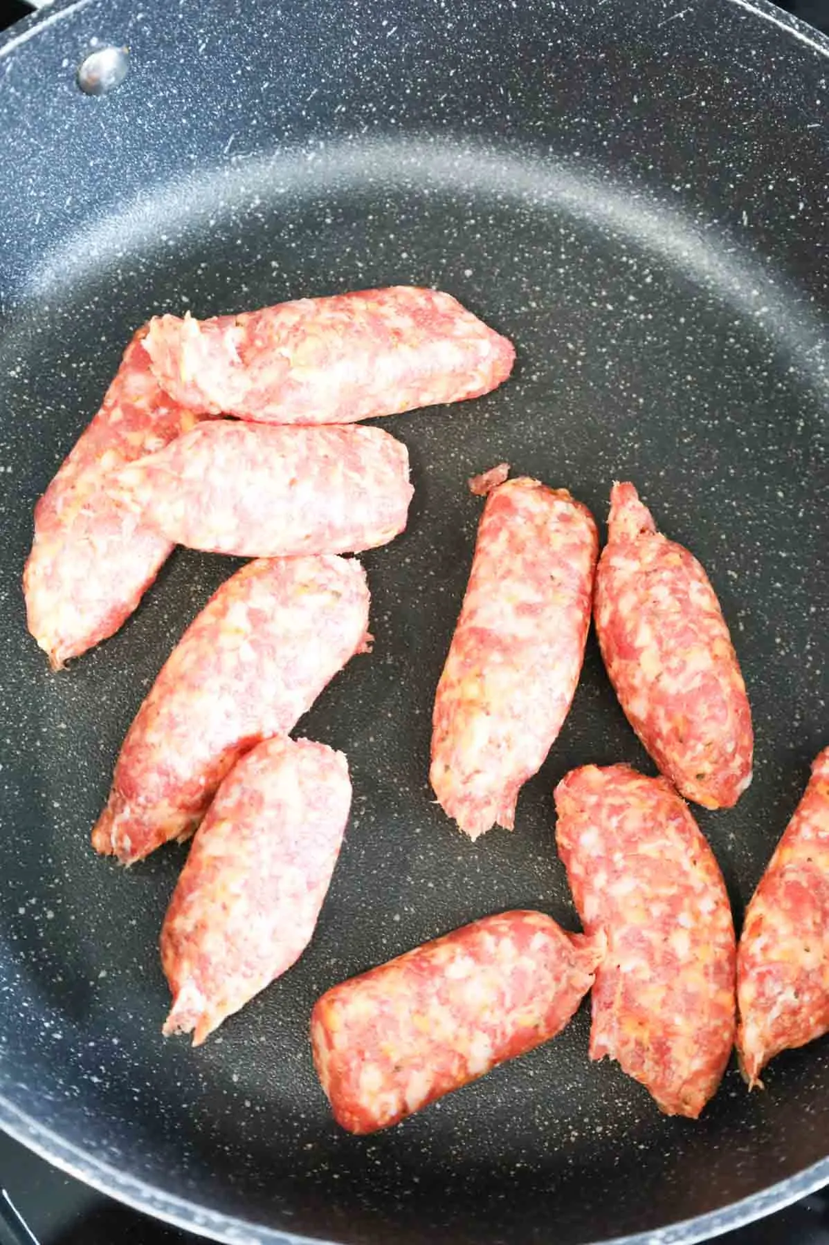 raw Italian sausage meat in a skillet