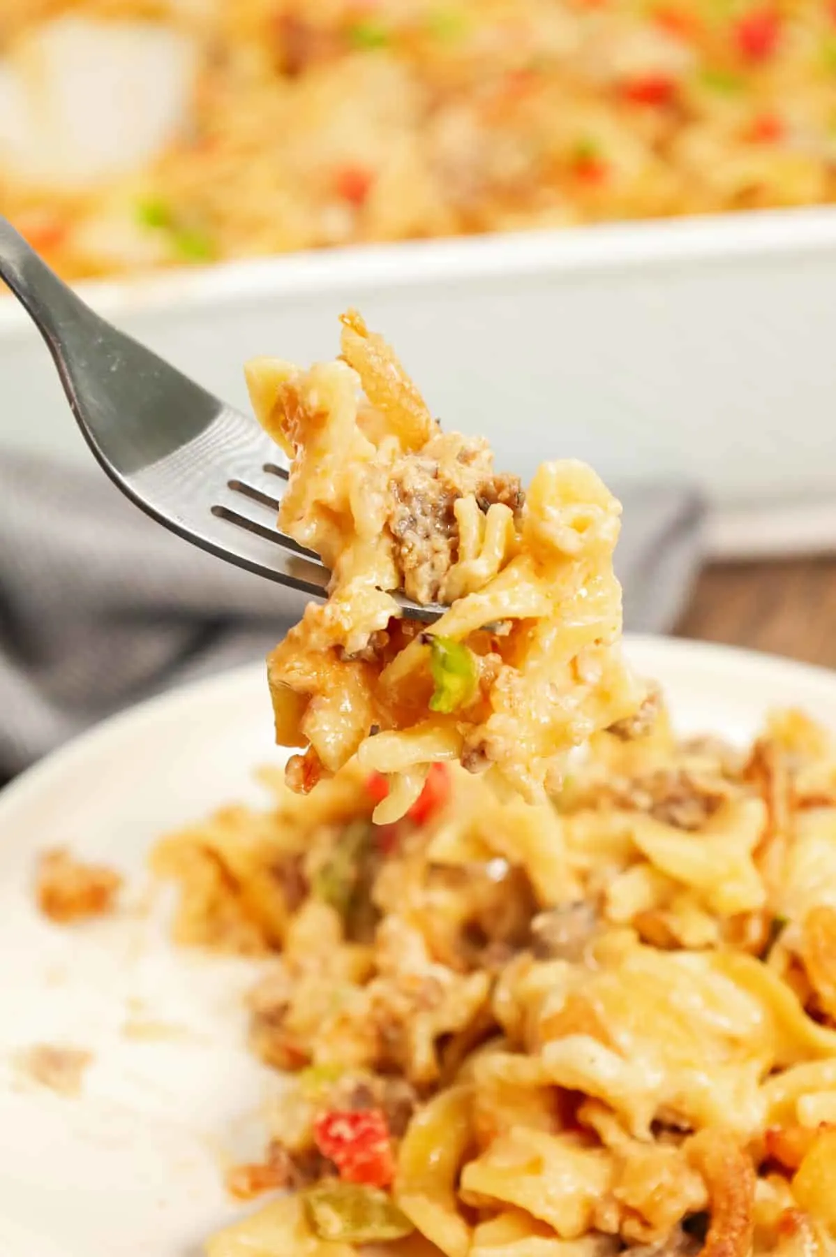 Sausage and Noodle Casserole is a hearty dinner recipe loaded with Italian sausage meat, egg noodle and diced bell peppers all tossed in a cream of mushroom and cream cheese mixture and baked with provolone cheese and French's crispy fried onions on top.
