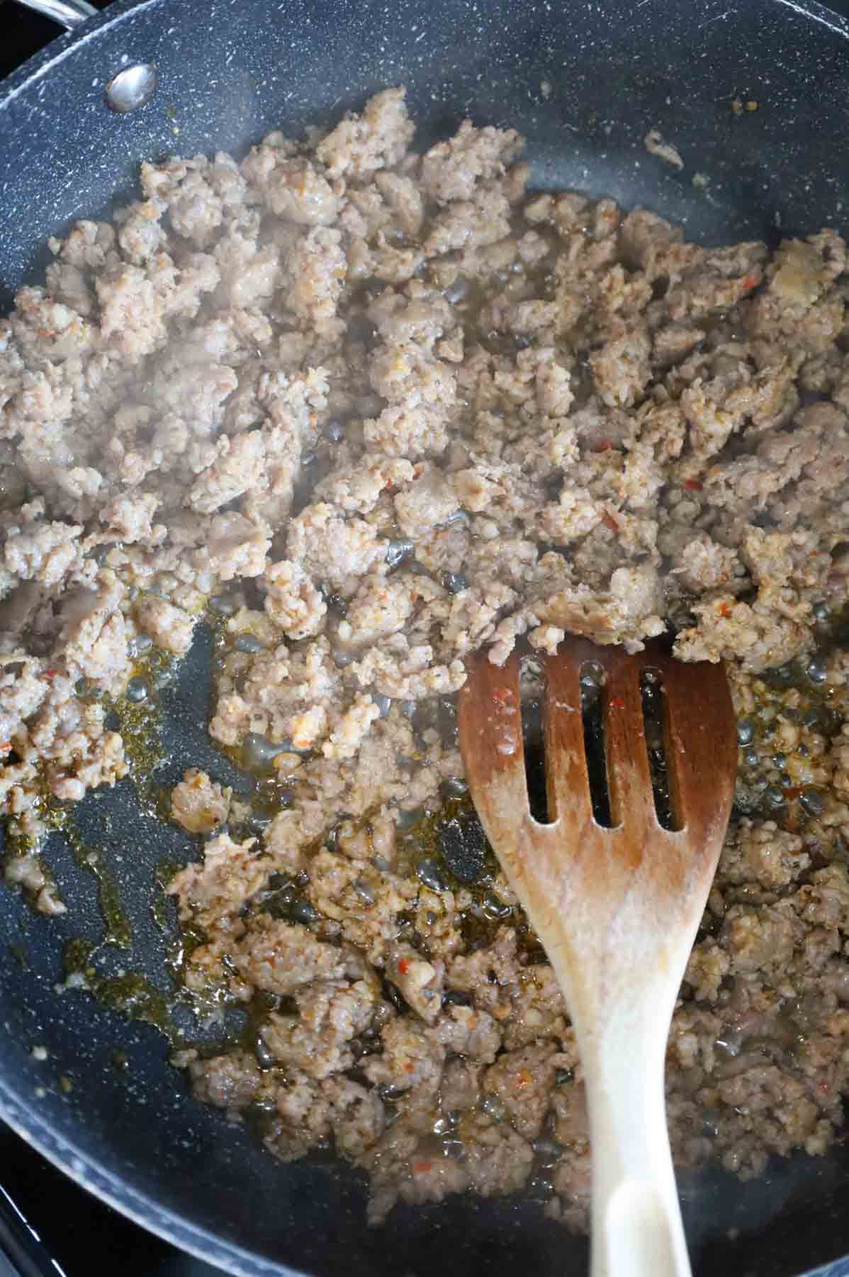 crumbled sausage cooking in a skillet