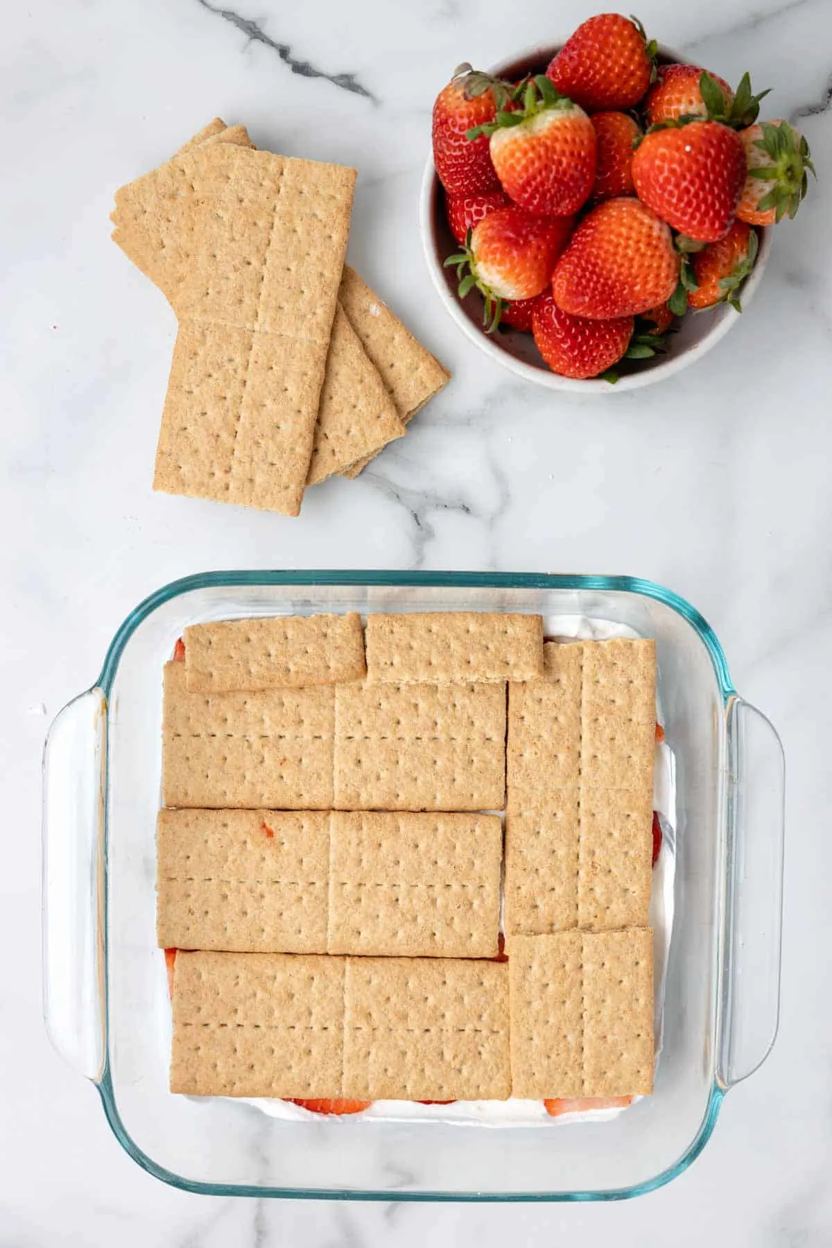 graham crackers in a layer on top of strawberries and cool whip