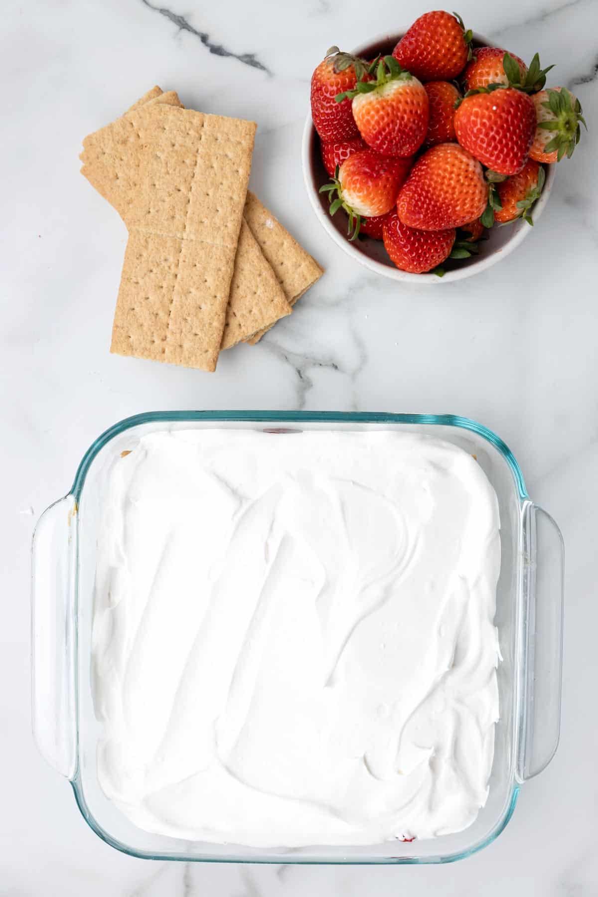 cool whip layer spread on top of strawberry icebox cake