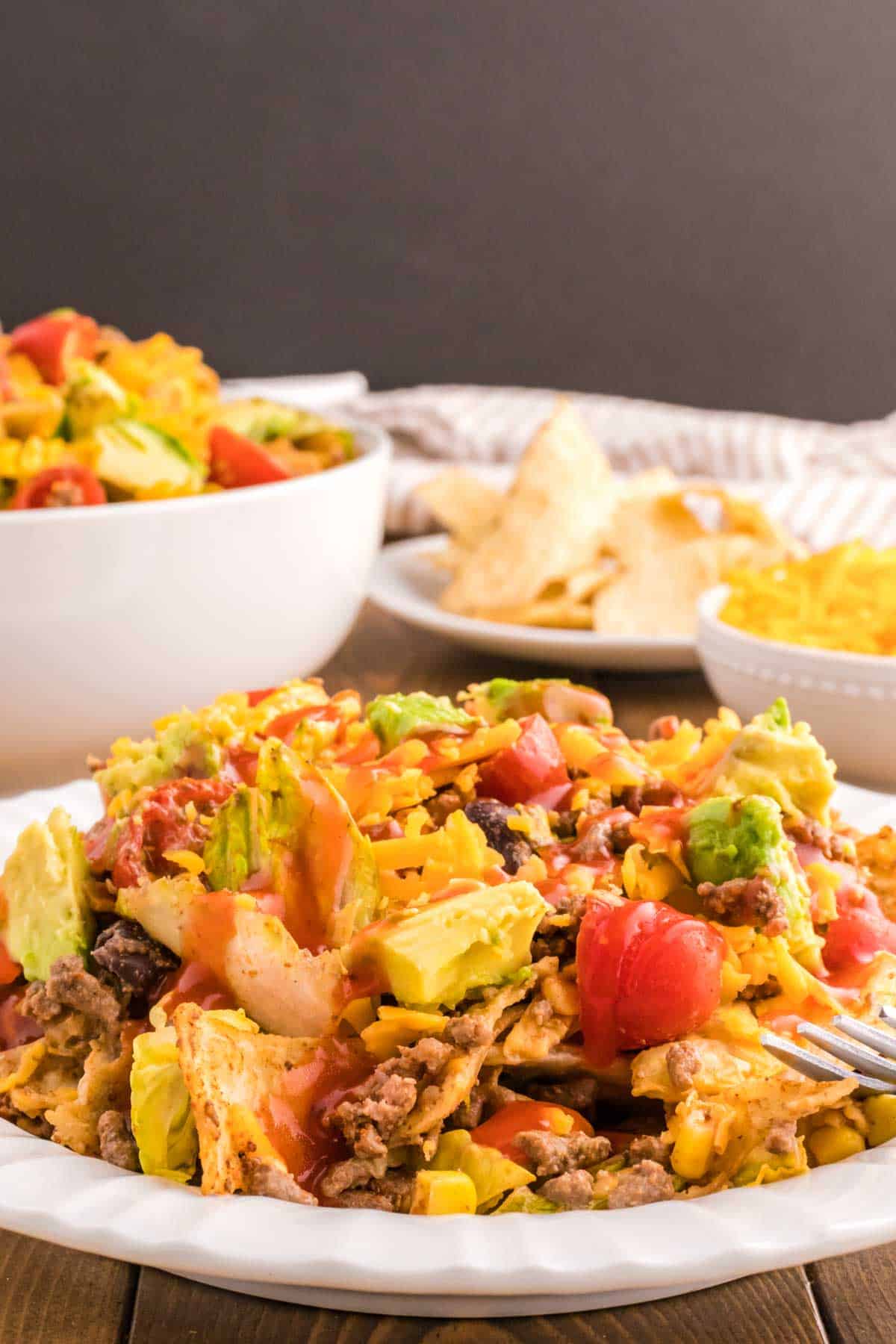 Taco Salad with Catalina Dressing is a hearty salad recipe loaded with taco seasoned ground beef, romaine lettuce, cherry tomatoes, cheddar cheese, crushed tortilla chips, corn, black bean and diced avocados all tossed in a sour cream and Catalina based dressing.