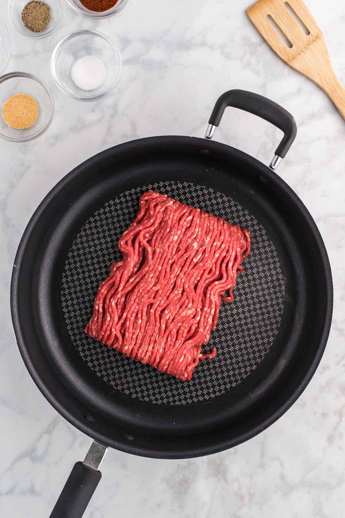 raw ground beef in a skillet