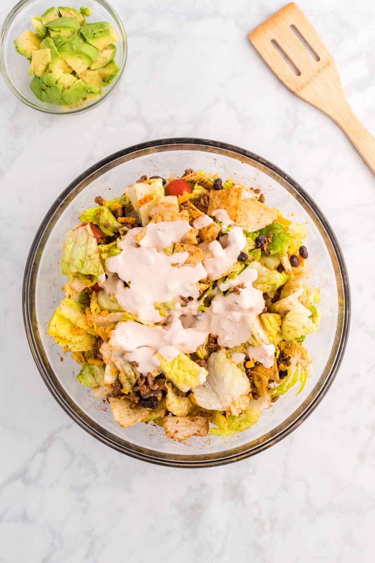 dressing poured over taco salad in a bowl