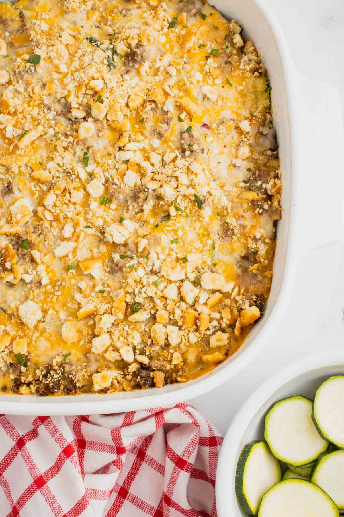 Zucchini Casserole with Ground Beef is a hearty casserole with layers of sliced zucchini, hamburger meat, a cream of mushroom based sauce mixture, shredded cheese and all baked with a Ritz cracker topping.