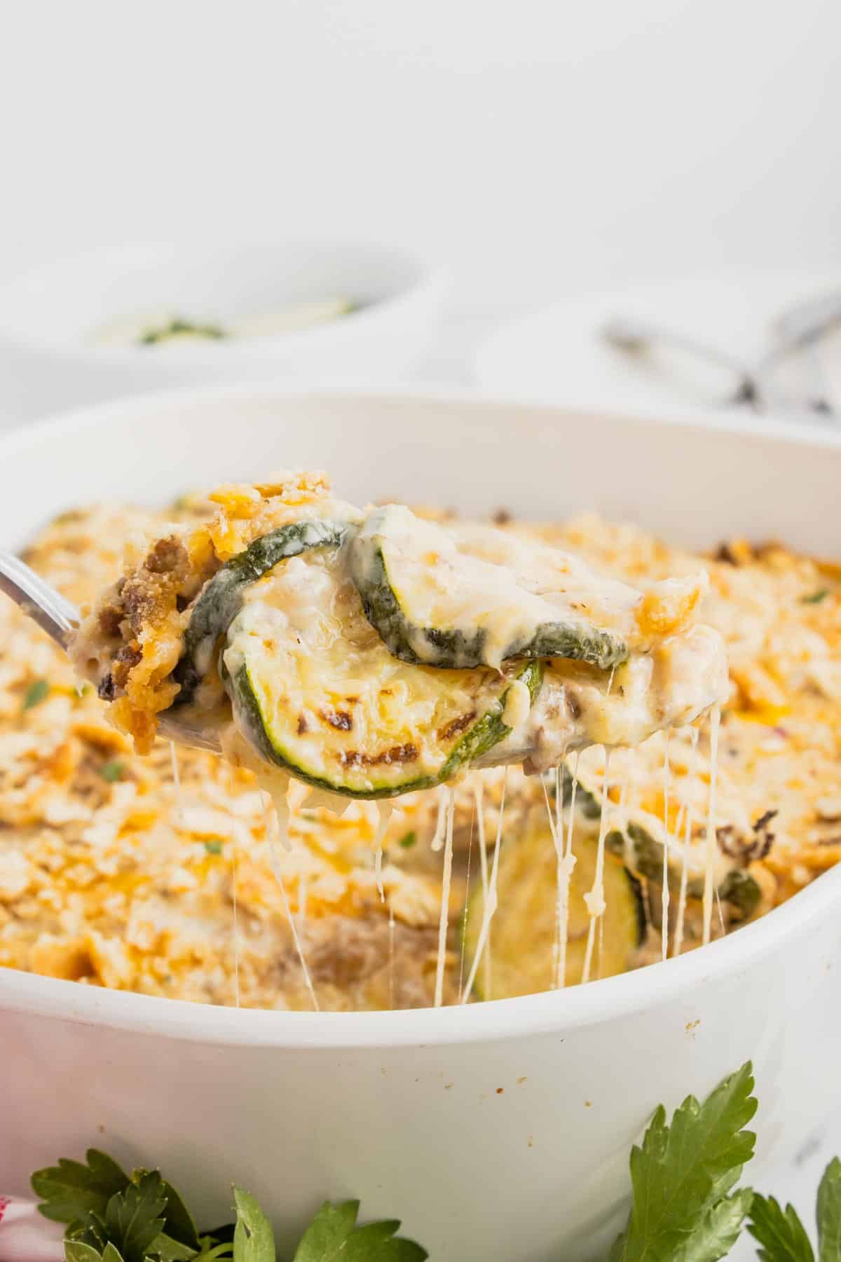 Zucchini Casserole with Ground Beef is a hearty casserole with layers of sliced zucchini, hamburger meat, a cream of mushroom based sauce mixture, shredded cheese and all baked with a Ritz cracker topping.