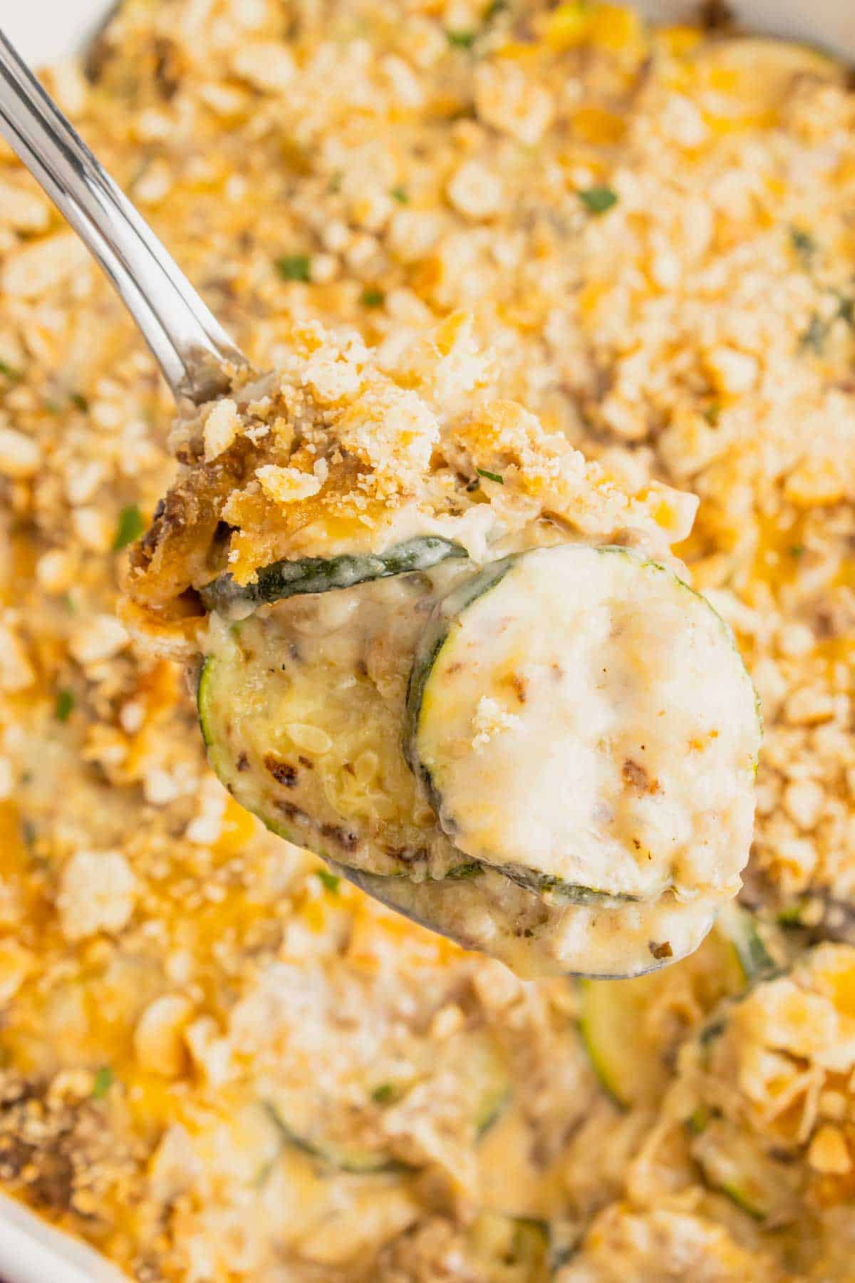 Zucchini Casserole with Ground Beef is a hearty casserole with layers of sliced zucchini, hamburger meat, a cream of mushroom based sauce mixture, shredded cheese and all baked with a Ritz cracker topping.