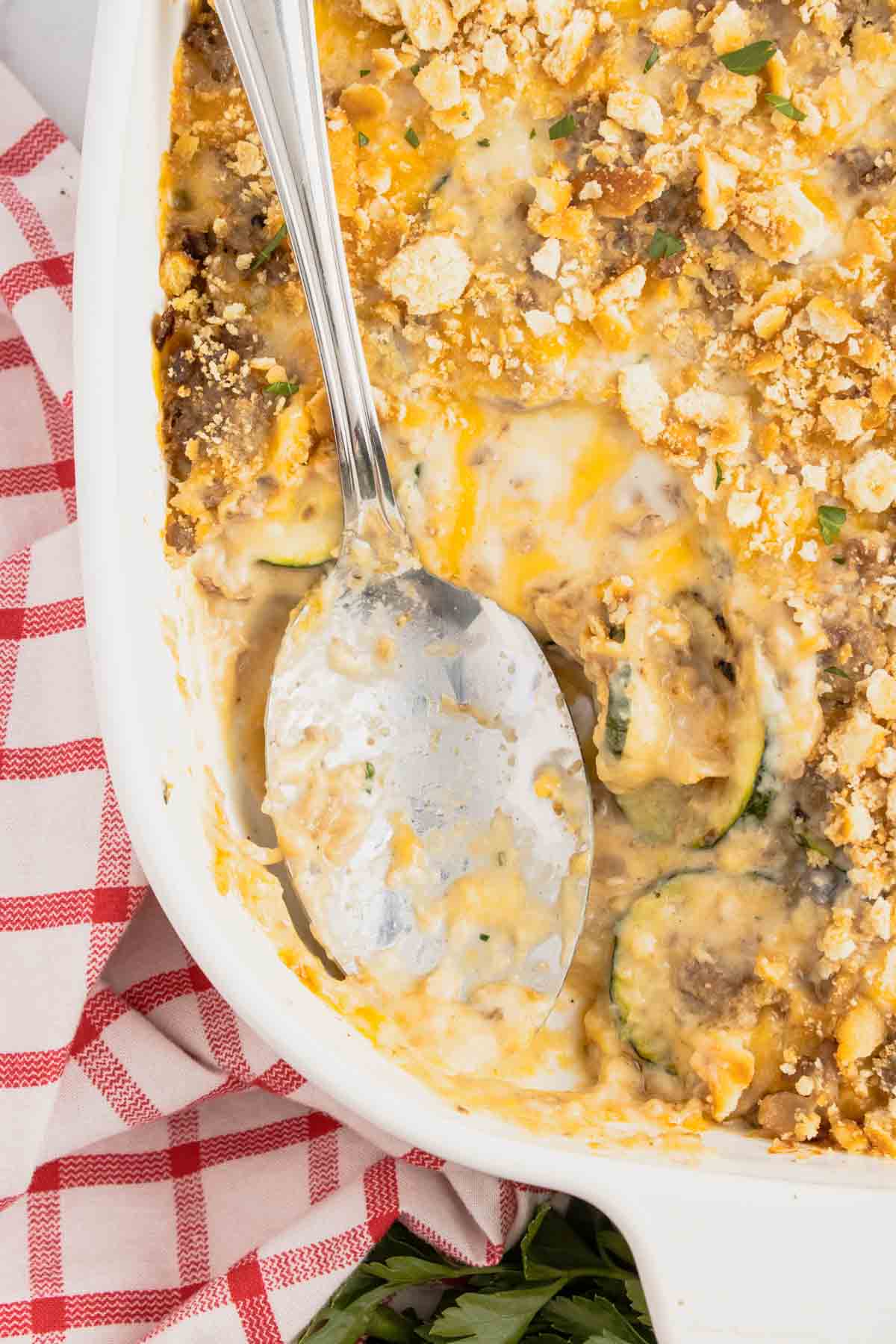 Zucchini Casserole with Ground Beef is a hearty casserole with layers of sliced zucchini, hamburger meat, a cream of mushroom based sauce mixture, shredded cheese and all baked with a Ritz cracker topping.