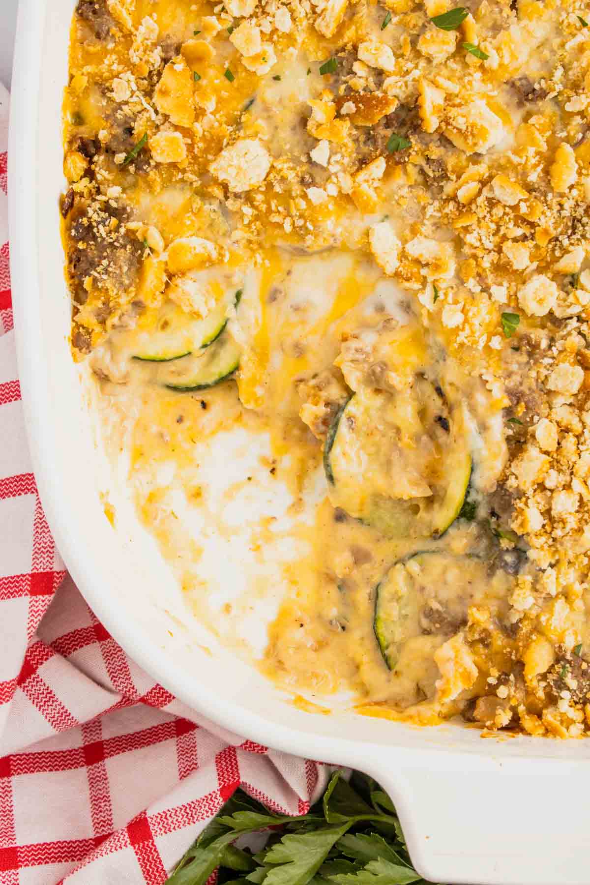 Zucchini Casserole with Ground Beef is a hearty casserole with layers of sliced zucchini, hamburger meat, a cream of mushroom based sauce mixture, shredded cheese and all baked with a Ritz cracker topping.