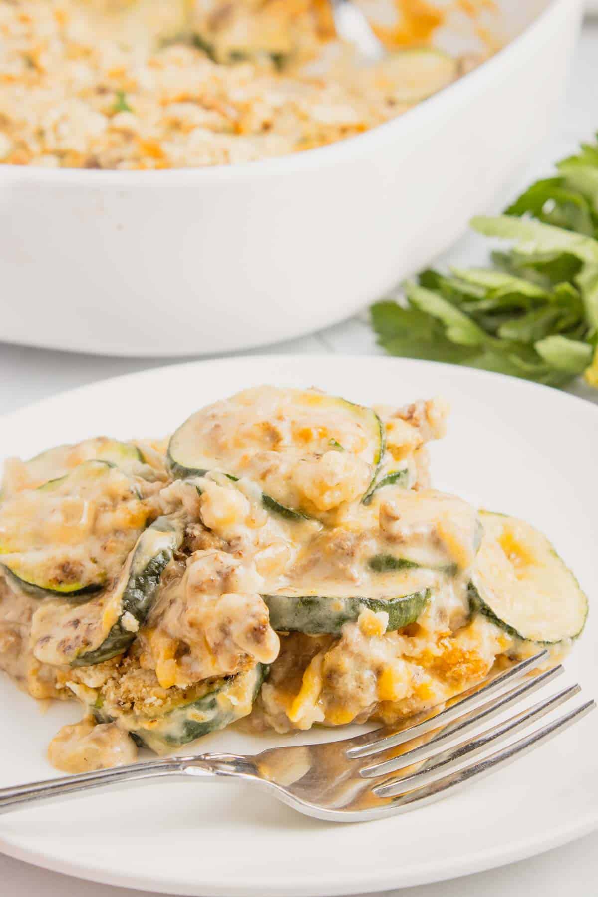Zucchini Casserole with Ground Beef is a hearty casserole with layers of sliced zucchini, hamburger meat, a cream of mushroom based sauce mixture, shredded cheese and all baked with a Ritz cracker topping.