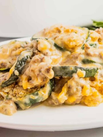 Zucchini Casserole with Ground Beef is a hearty casserole with layers of sliced zucchini, hamburger meat, a cream of mushroom based sauce mixture, shredded cheese and all baked with a Ritz cracker topping.