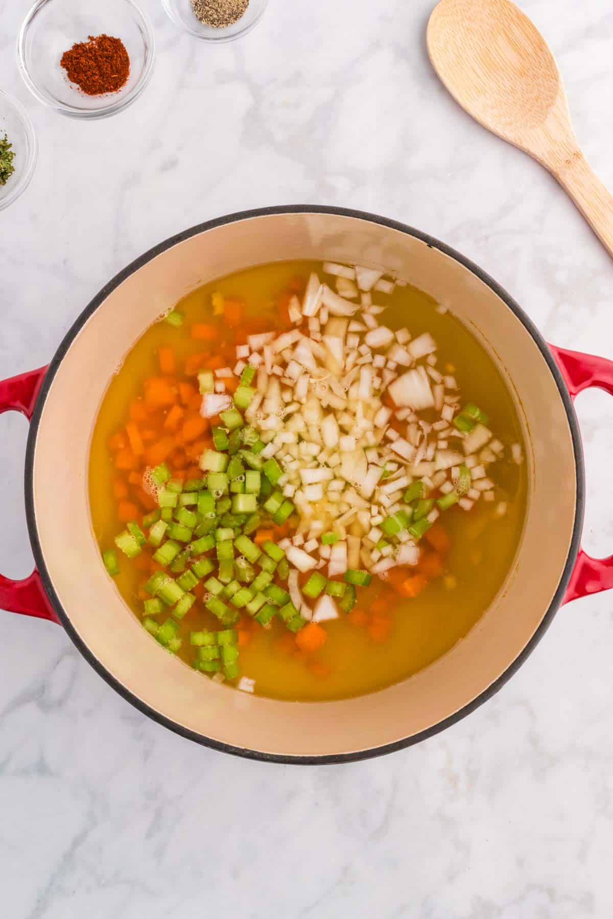 minced garlic, diced carrots, onions and celery added to pot with broth