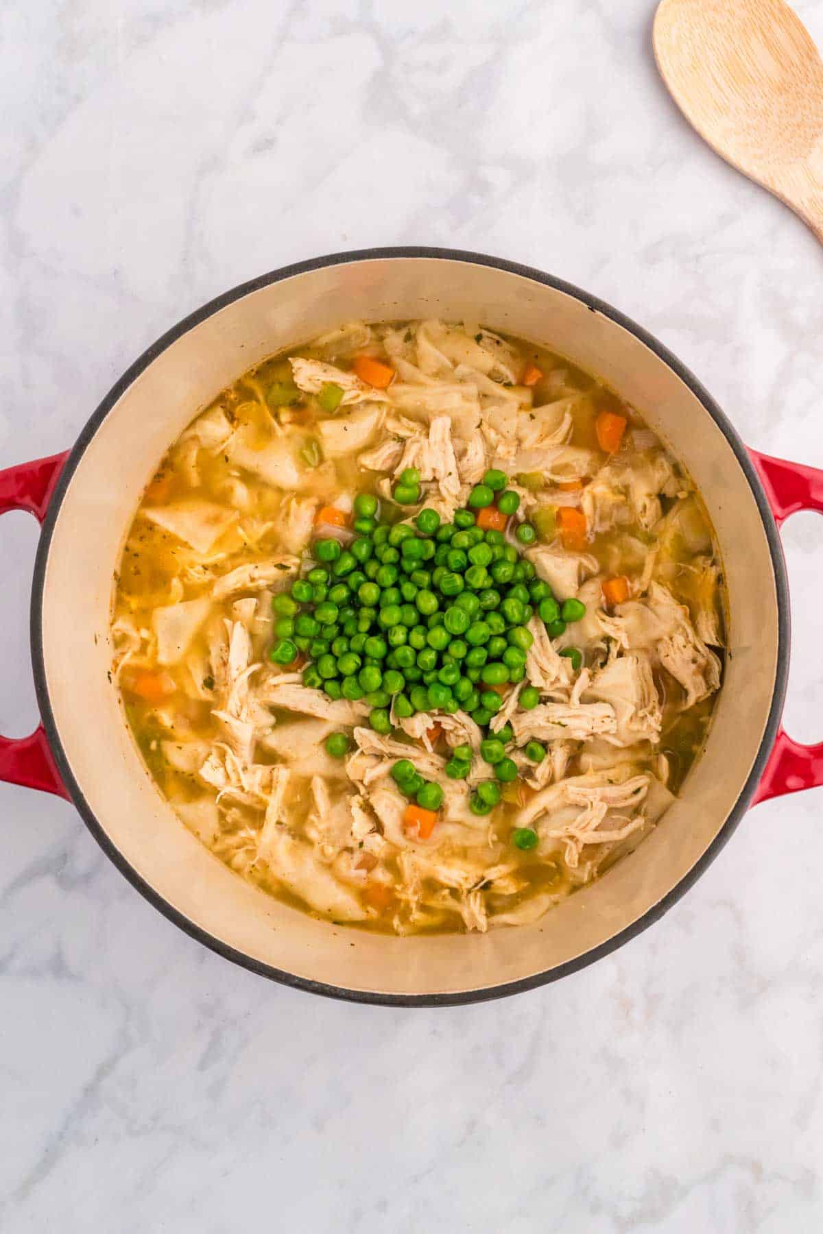 peas added to a pot with chicken and dumplings