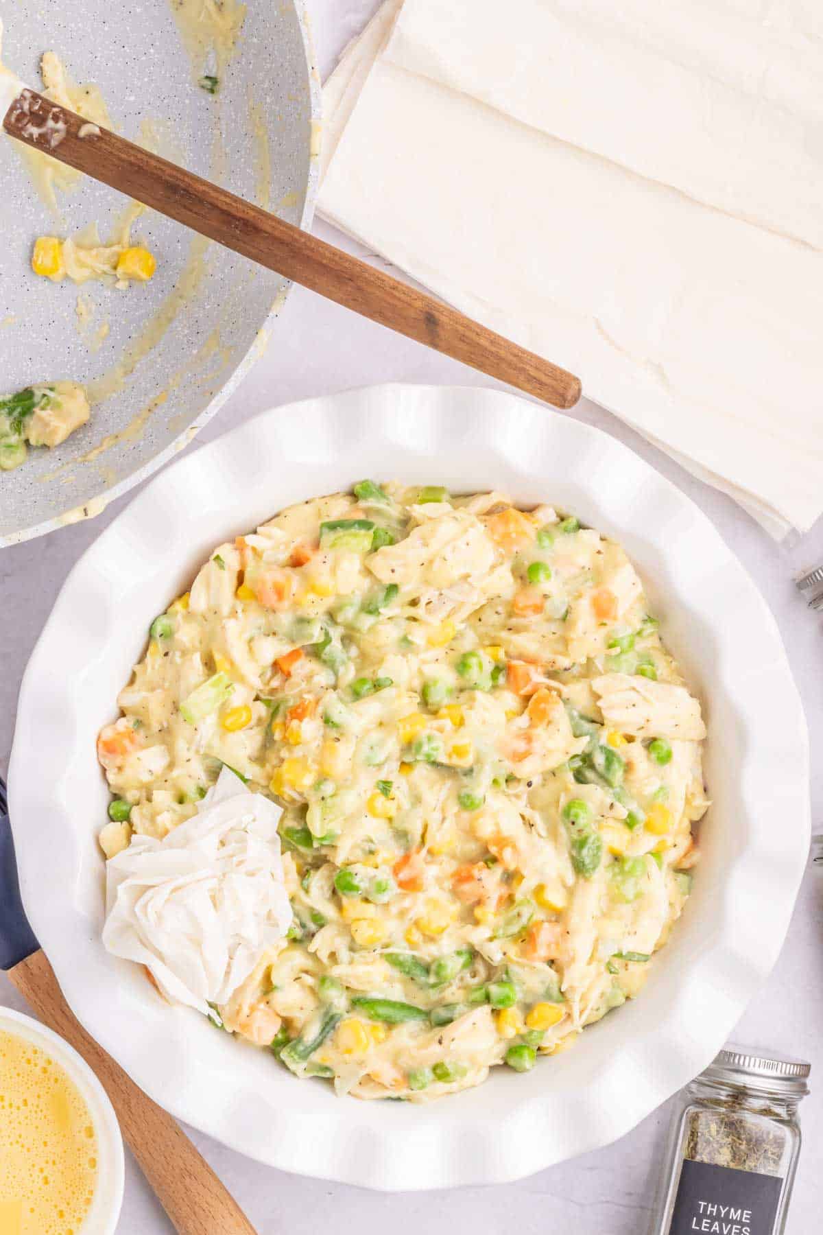 one ball of phyllo dough on top of chicken and veggie mixture in a round baking dish