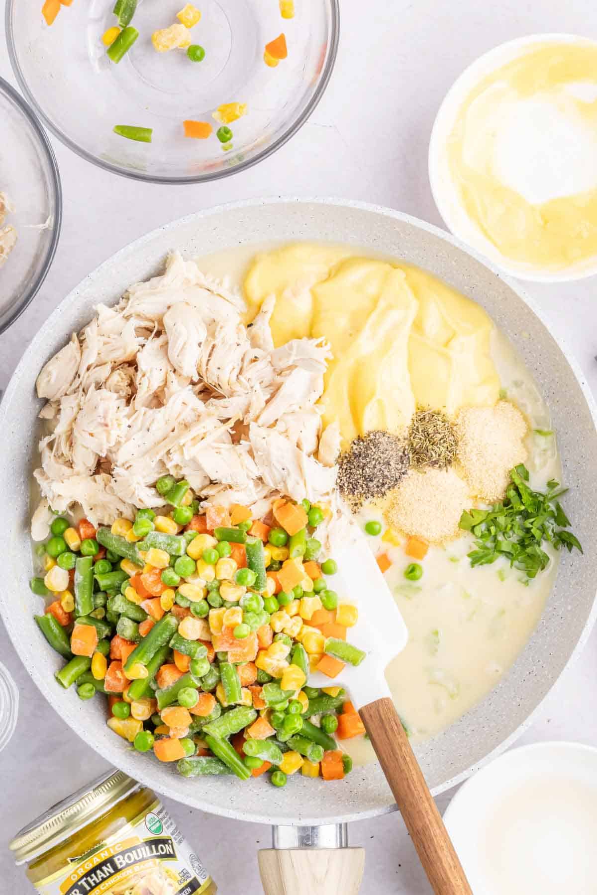 shredded rotisserie chicken, cream of chicken soup, spices, and frozen mixed veggies added to skillet with broth mixture