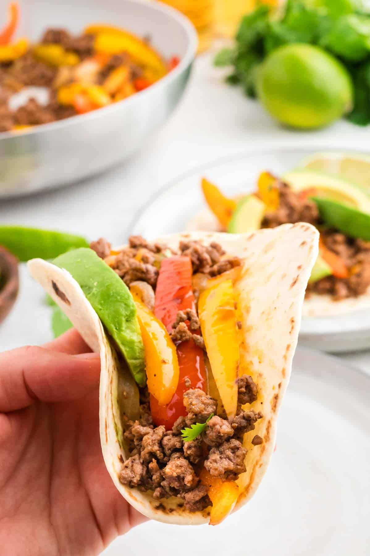 Ground Beef Fajitas are a simple weeknight meal with cooked ground beef, bell peppers and onions all seasoned with a homemade fajita spice blend and served on flour tortillas.