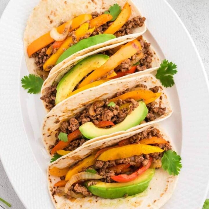 Ground Beef Fajitas are a simple weeknight meal with cooked ground beef, bell peppers and onions all seasoned with a homemade fajita spice blend and served on flour tortillas.