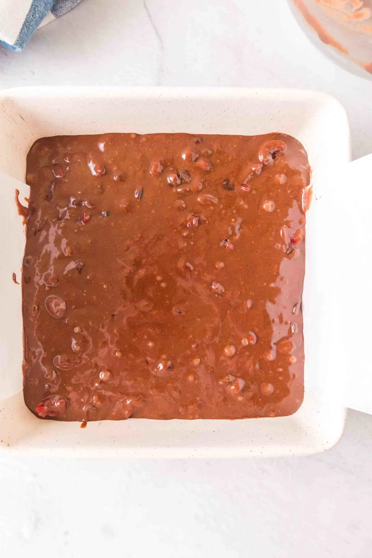 brownie batter in a parchment lined baking sheet