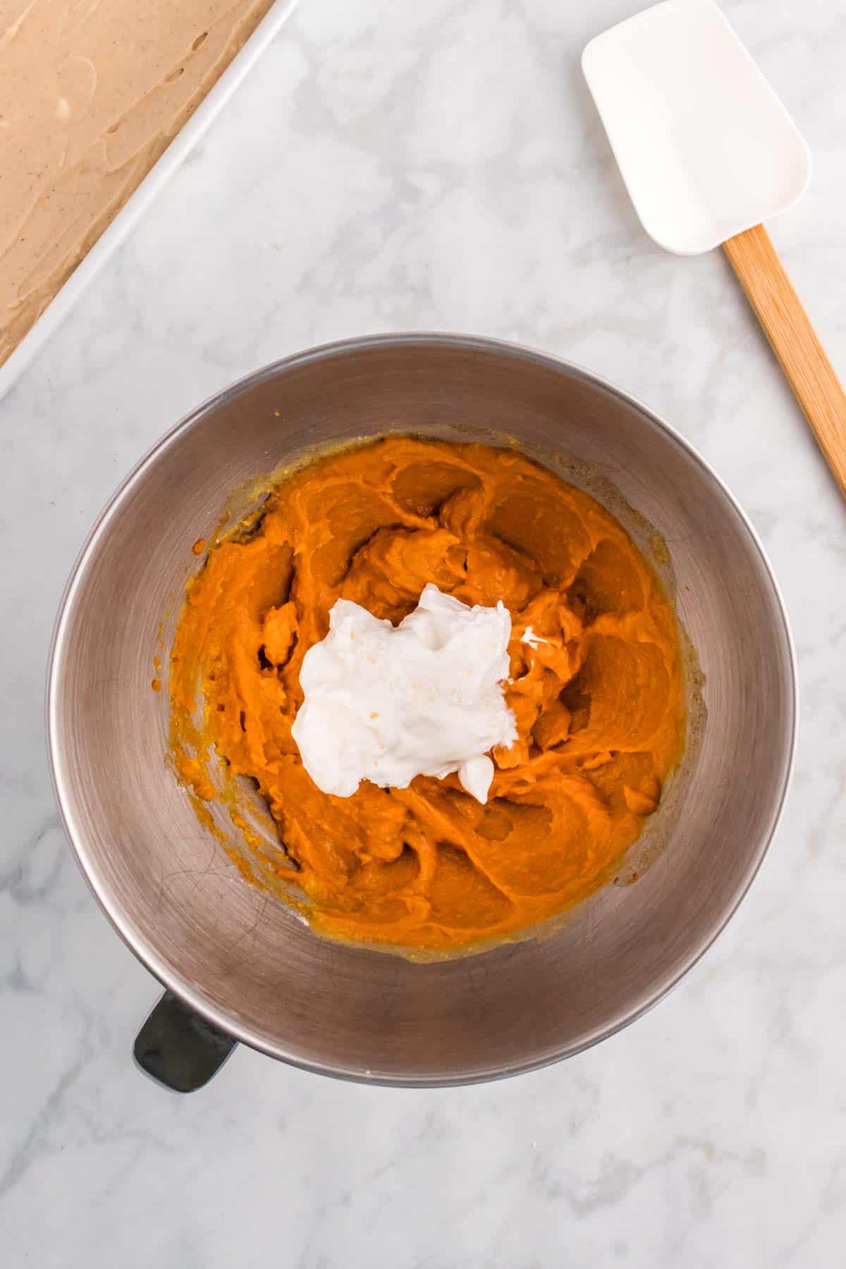 Cool Whip added to mixing bowl with pumpkin pudding mixture