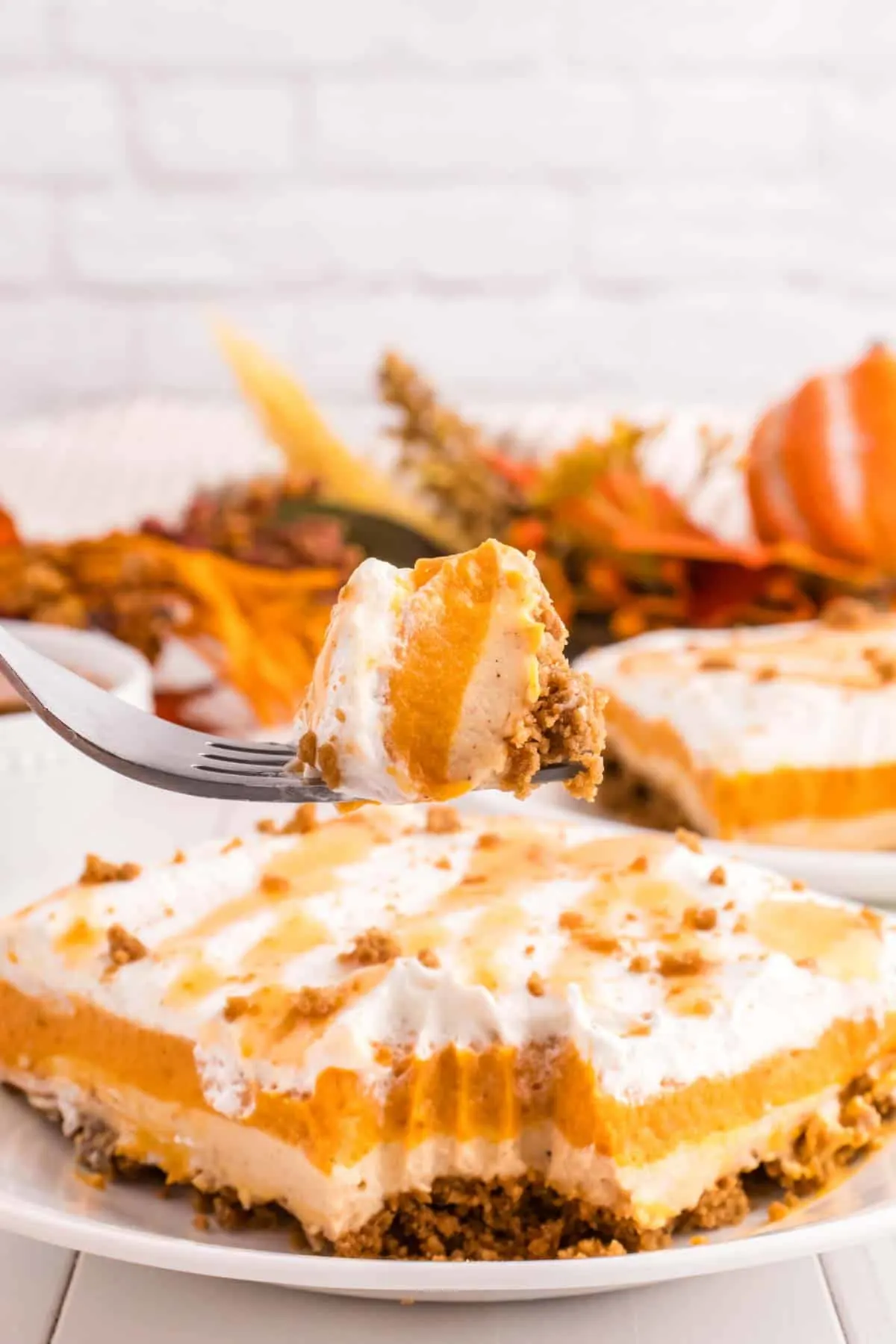 Pumpkin Delight is a rich and creamy dessert with layers of whipped topping, pumpkin pudding mousse mixture, cinnamon cheesecake and a gingersnap cookie crust.