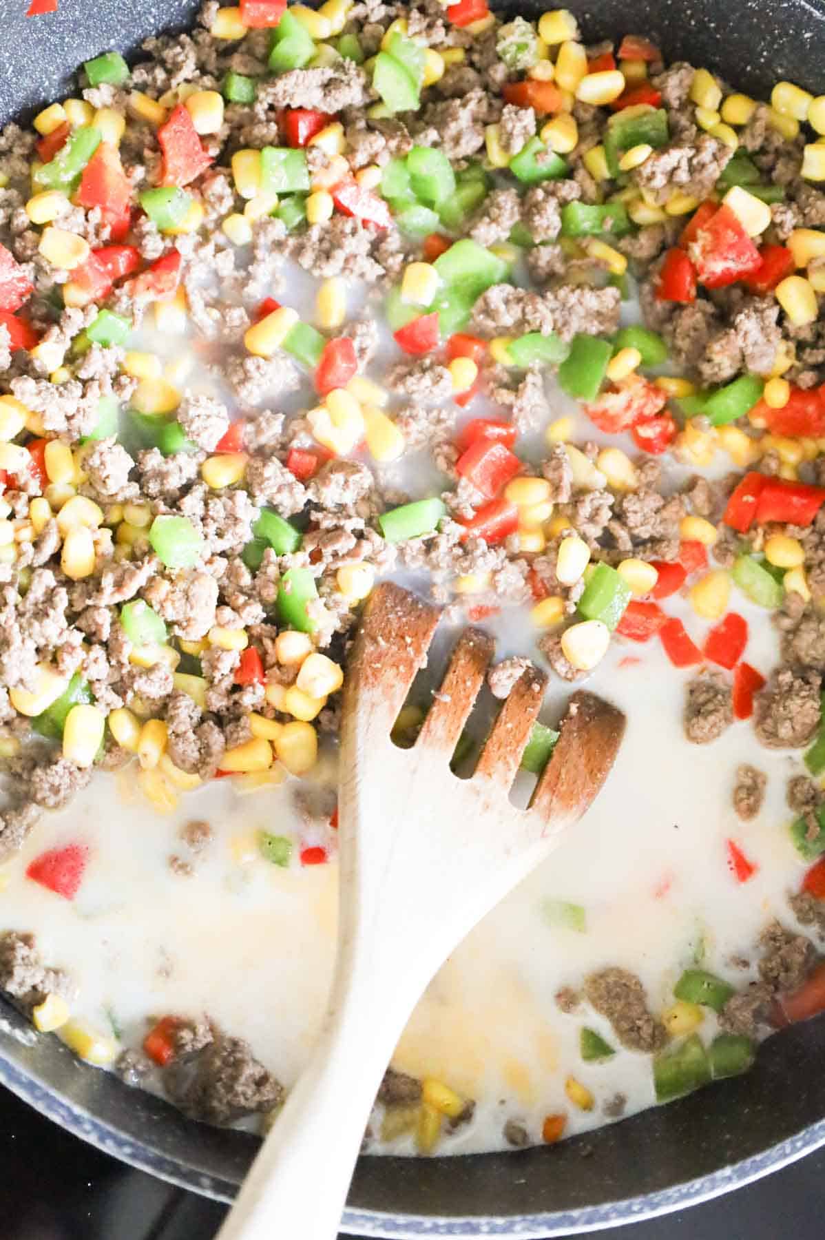 milk and water added to skillet with ground beef and veggie mixture