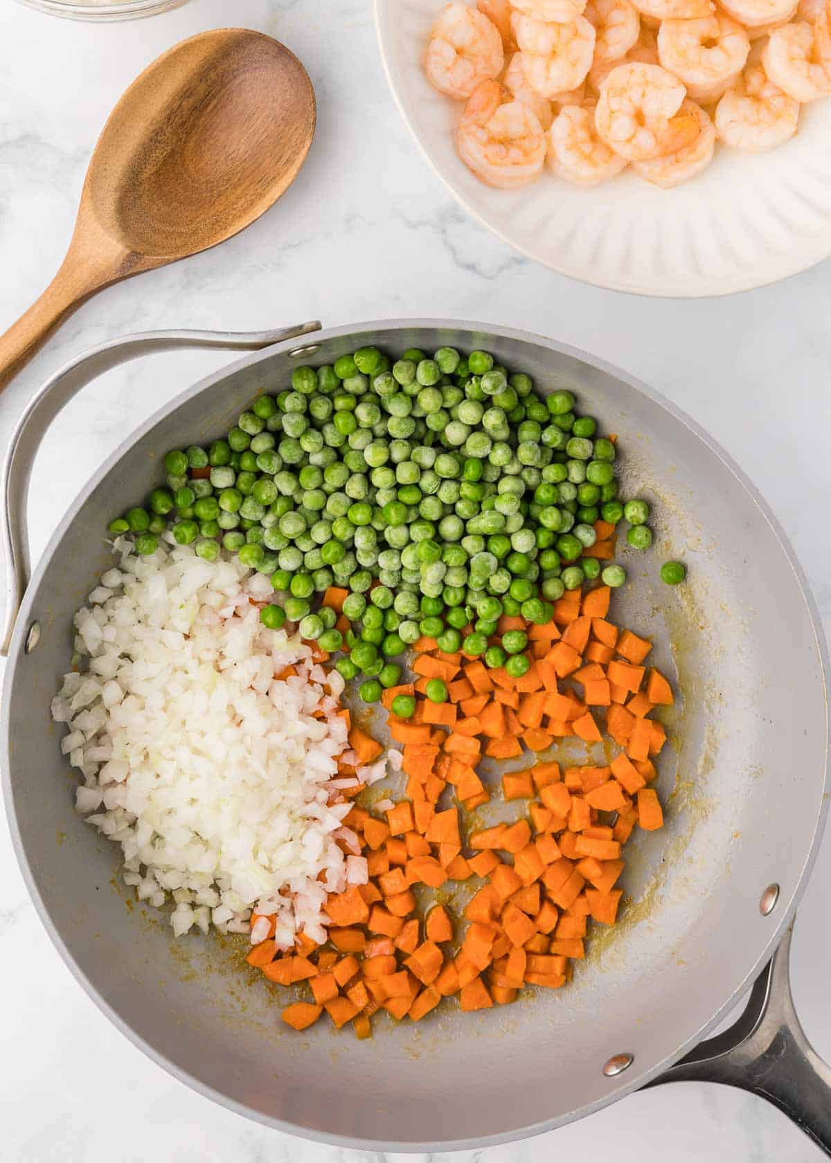 peas, chopped onions and carrots in a skillet
