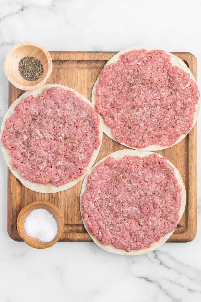 ground beef flattened onto flour tortillas