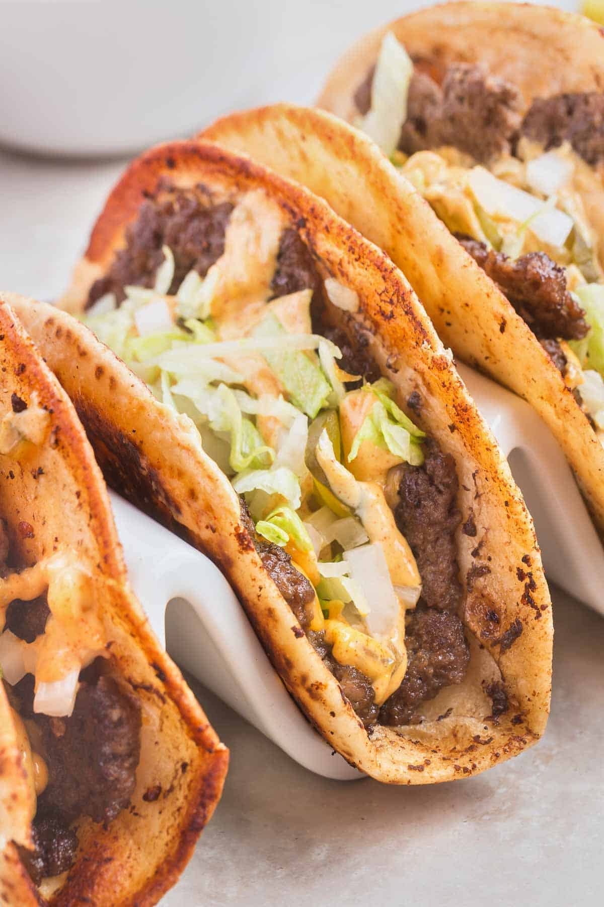 Smash Burger Tacos are a delightful fusion of two classic foods made with flour tortillas topped with ground beef patties, cheese, onions, pickles, shredded lettuce and homemade copycat Big Mac sauce.
