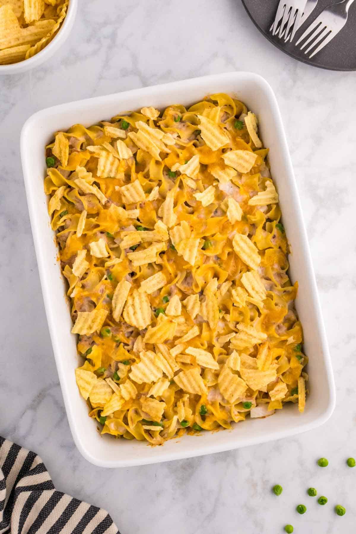 Tuna Casserole with Potato Chips is an easy dinner recipe loaded with egg noodles, canned tuna, peas, diced onions, cream of mushroom soup and shredded cheddar cheese with a crushed potato chip topping.