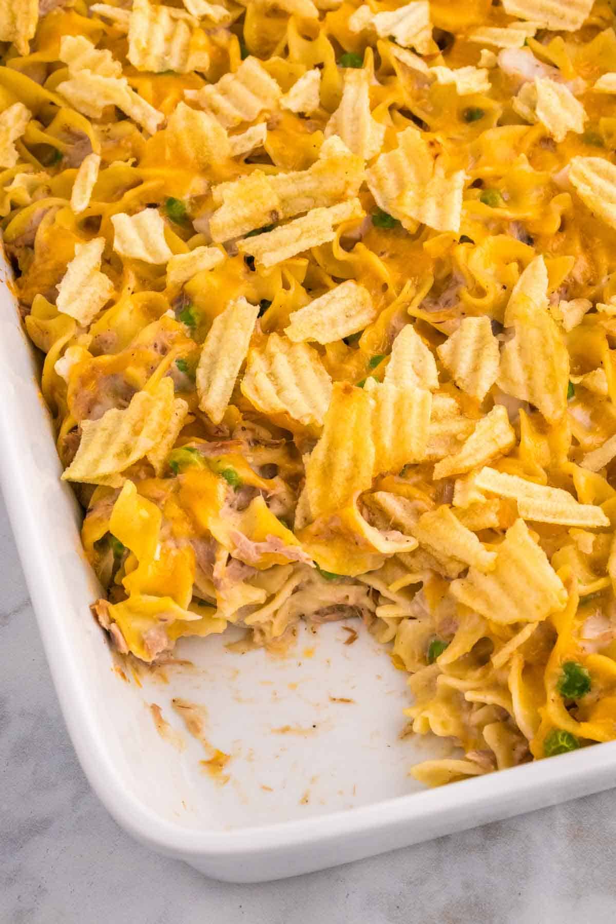 Tuna Casserole with Potato Chips is an easy dinner recipe loaded with egg noodles, canned tuna, peas, diced onions, cream of mushroom soup and shredded cheddar cheese with a crushed potato chip topping.