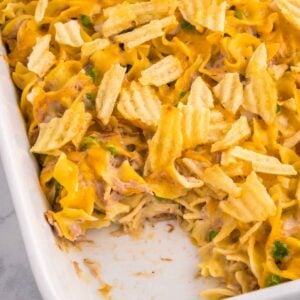 Tuna Casserole with Potato Chips is an easy dinner recipe loaded with egg noodles, canned tuna, peas, diced onions, cream of mushroom soup and shredded cheddar cheese with a crushed potato chip topping.