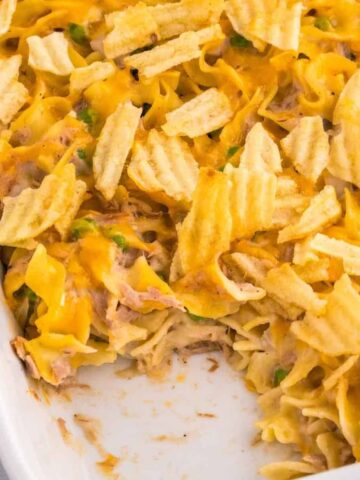Tuna Casserole with Potato Chips is an easy dinner recipe loaded with egg noodles, canned tuna, peas, diced onions, cream of mushroom soup and shredded cheddar cheese with a crushed potato chip topping.