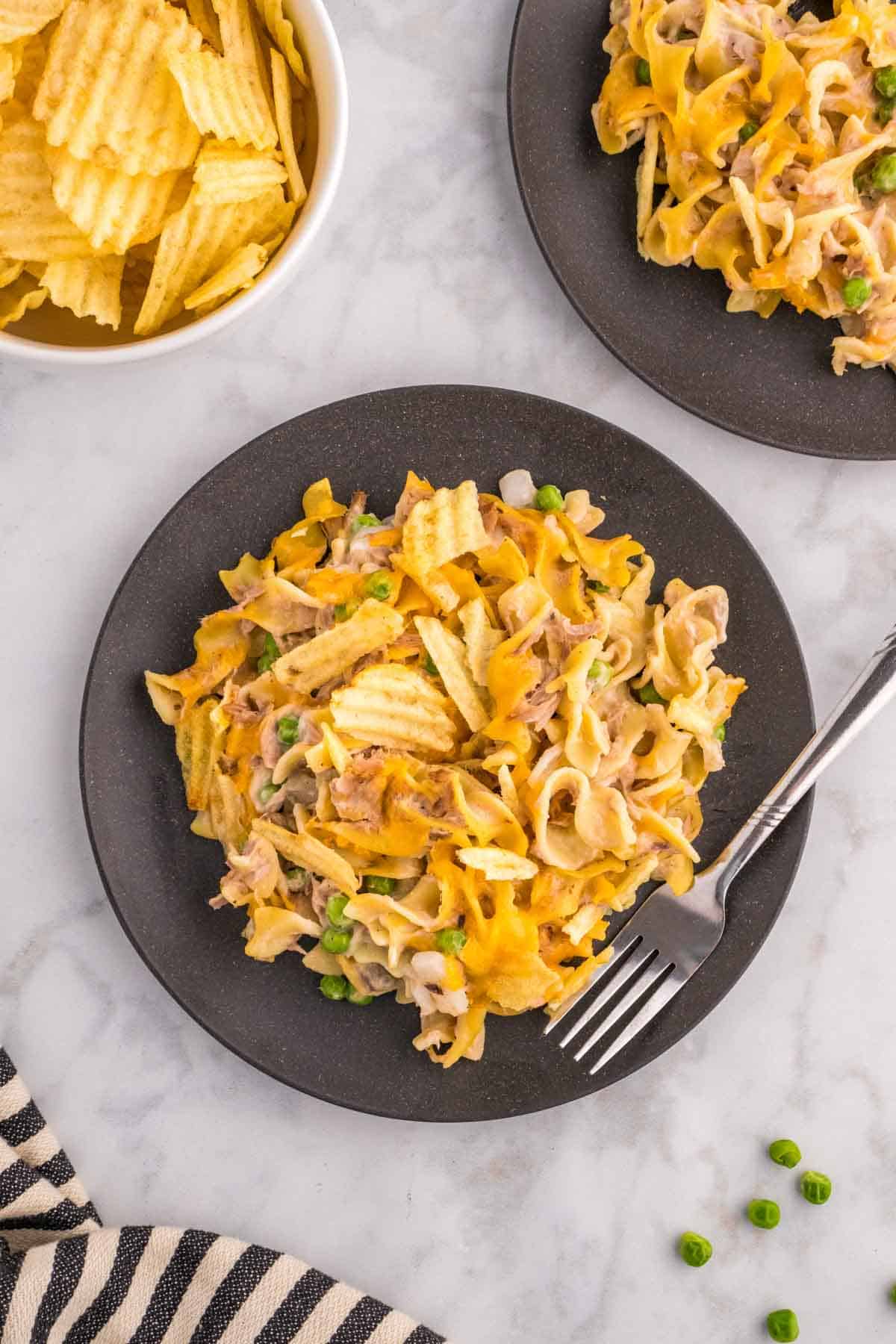 Tuna Casserole with Potato Chips is an easy dinner recipe loaded with egg noodles, canned tuna, peas, diced onions, cream of mushroom soup and shredded cheddar cheese with a crushed potato chip topping.