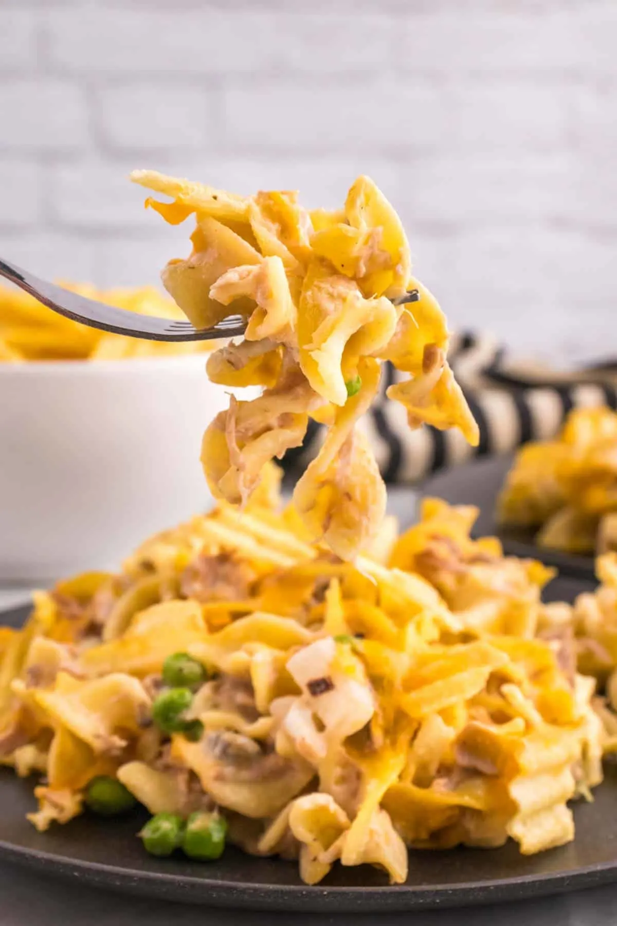 Tuna Casserole with Potato Chips is an easy dinner recipe loaded with egg noodles, canned tuna, peas, diced onions, cream of mushroom soup and shredded cheddar cheese with a crushed potato chip topping.
