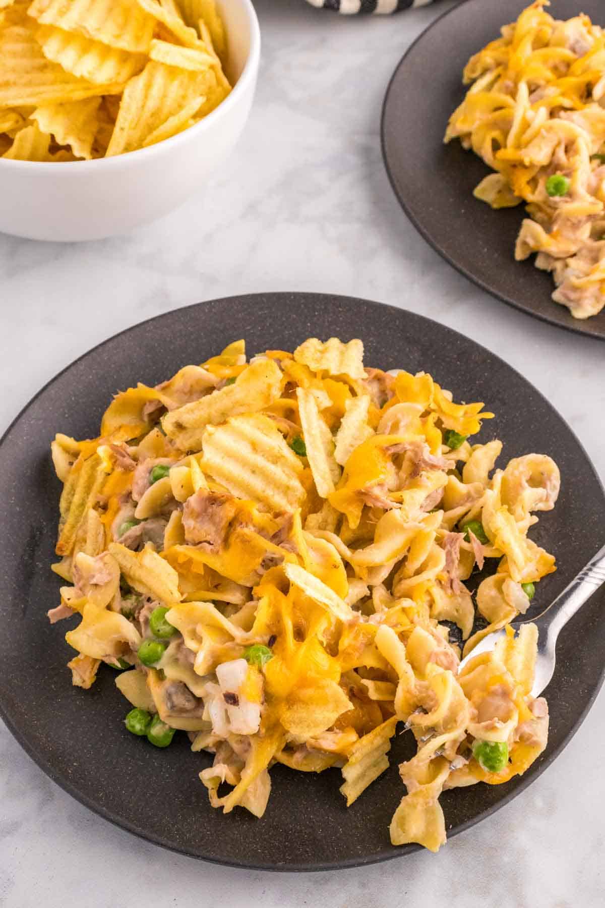 Tuna Casserole with Potato Chips is an easy dinner recipe loaded with egg noodles, canned tuna, peas, diced onions, cream of mushroom soup and shredded cheddar cheese with a crushed potato chip topping.