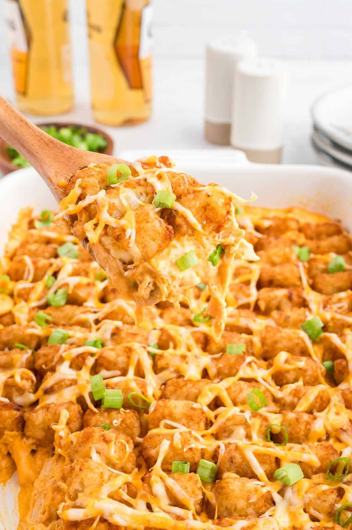 Buffalo Chicken Tater Tot Casserole is an easy family friendly dinner recipe  loaded with rotisserie chicken, cream of chicken soup, cream cheese, ranch dressing, Frank's Red Hot, tater tots, shredded cheese and chopped green onions.