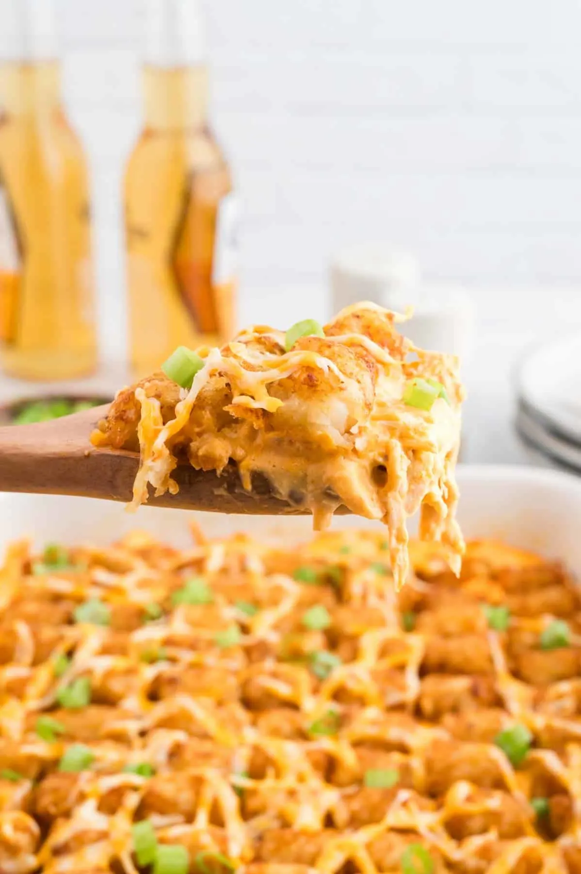 Buffalo Chicken Tater Tot Casserole is an easy family friendly dinner recipe  loaded with rotisserie chicken, cream of chicken soup, cream cheese, ranch dressing, Frank's Red Hot, tater tots, shredded cheese and chopped green onions.