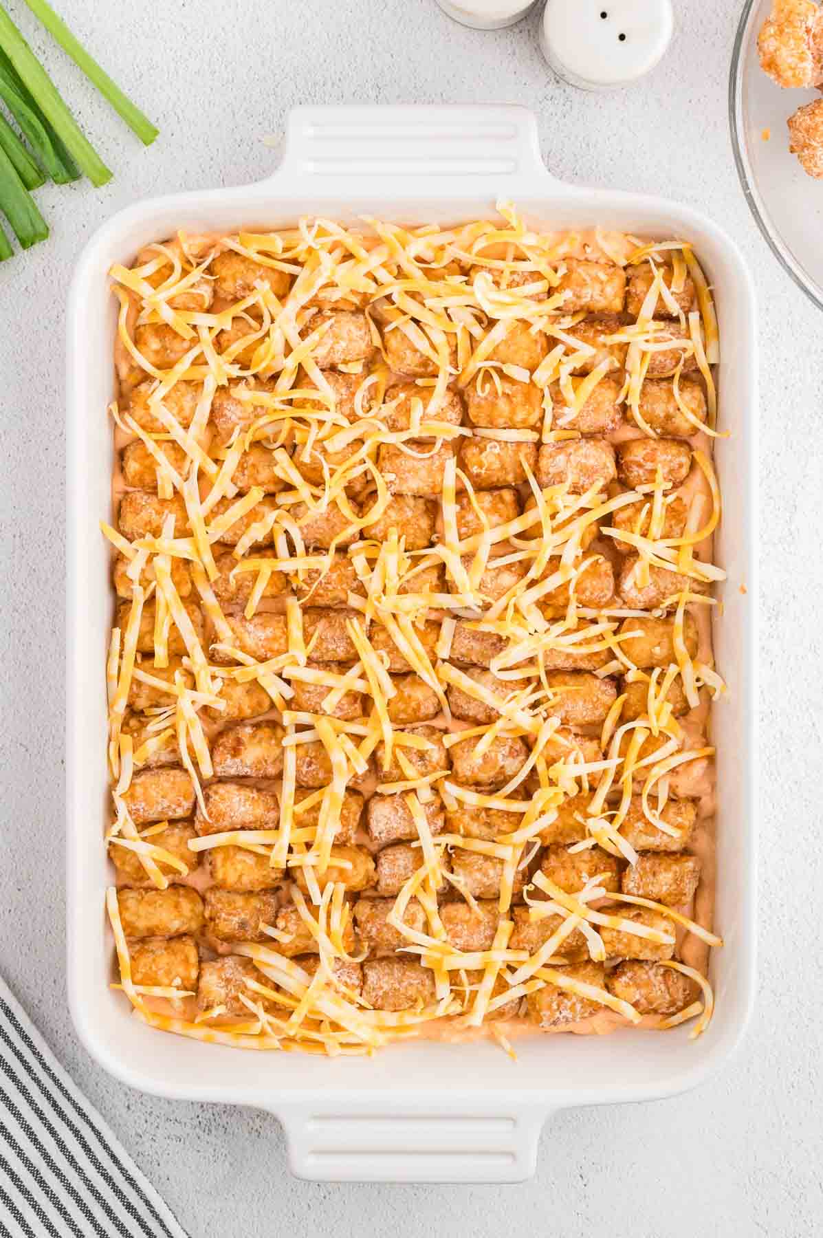 shredded chicken on top of Buffalo chicken tater tot casserole