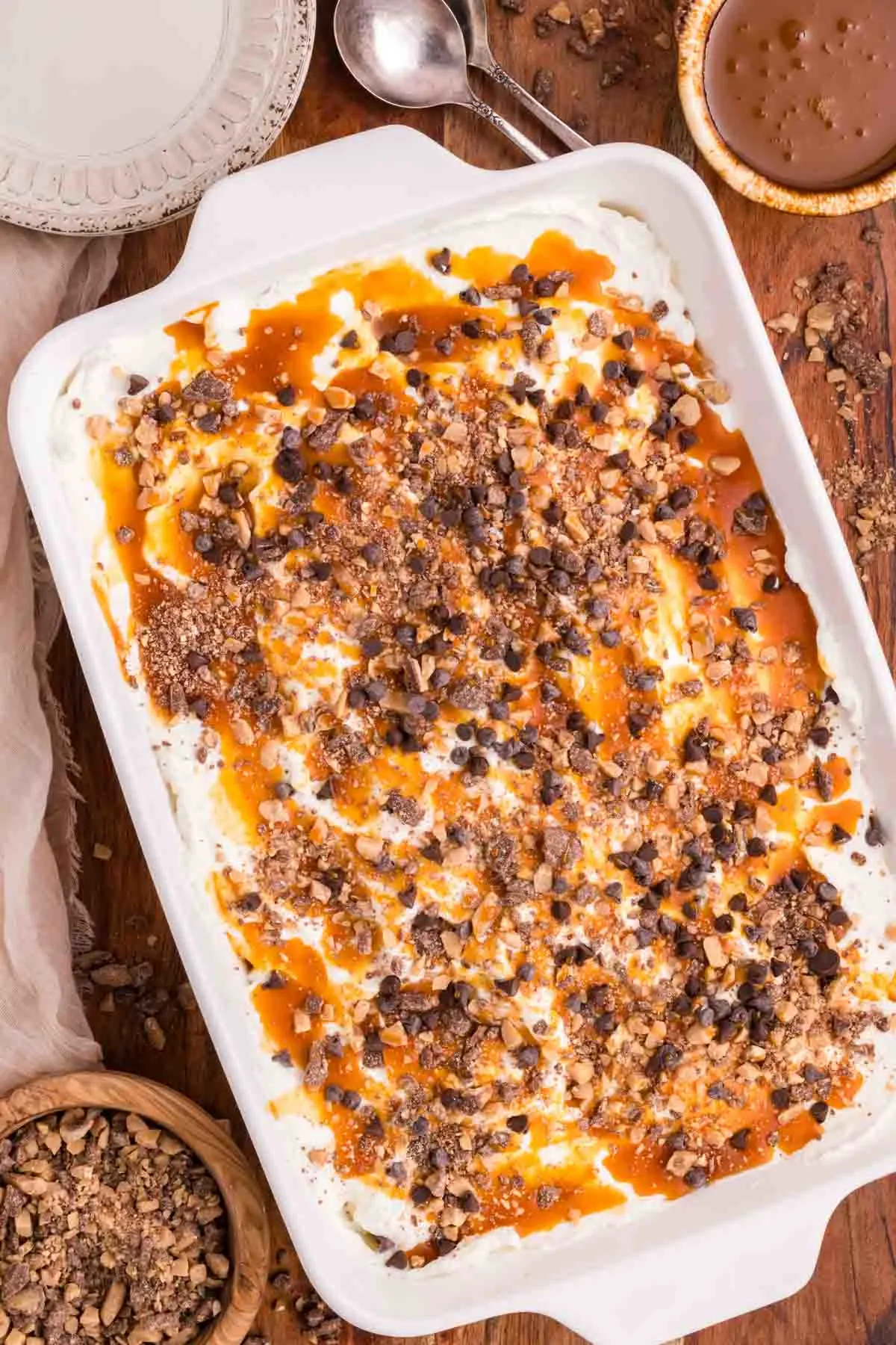 Chocolate Caramel Poke Cake is a decadent chocolate cake soaked with caramel and topped with whipped cream, caramel sauce, chocolate chips and crumbled Heath bars.