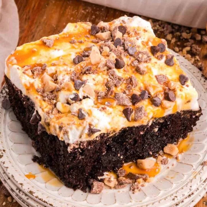 Chocolate Caramel Poke Cake is a decadent chocolate cake soaked with caramel and topped with whipped cream, caramel sauce, chocolate chips and crumbled Heath bars.