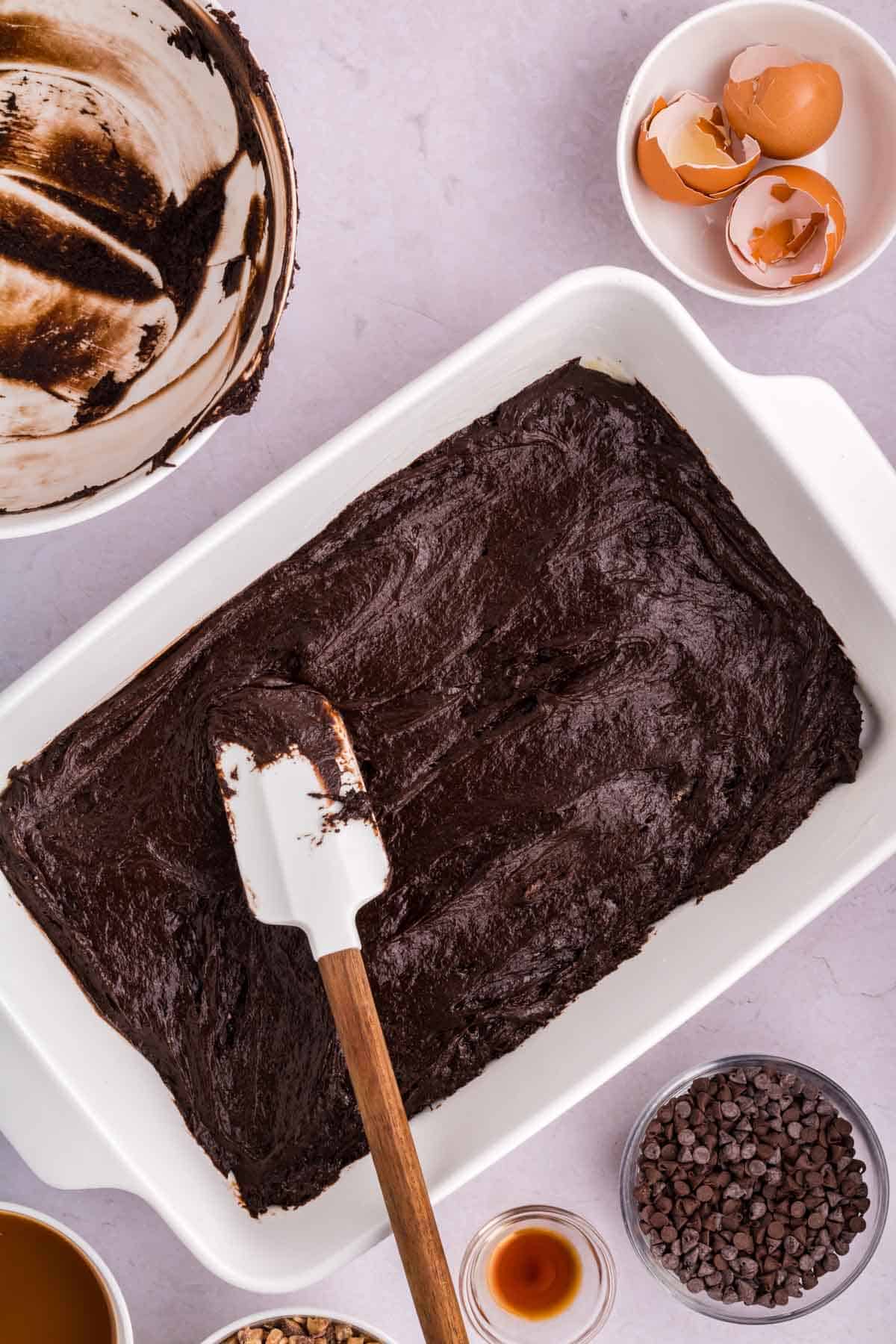spreading chocolate cake batter in a 9 x 13 inch baking dish