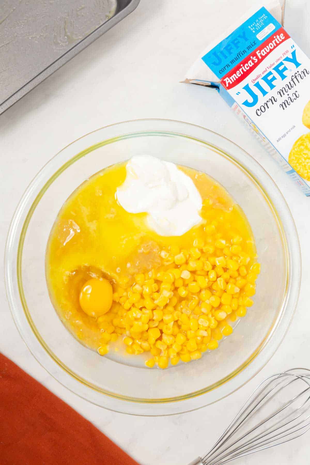 sour cream, egg, whole kernel corn and cream corn in a mixing bowl