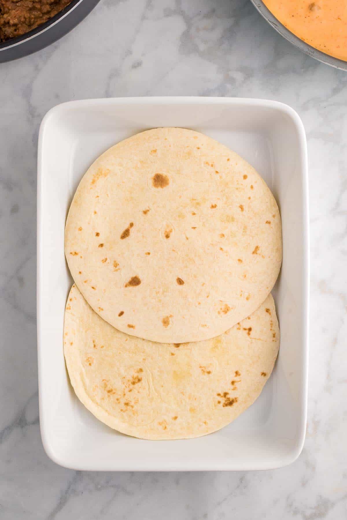 flour tortillas in the bottom of a baking dish