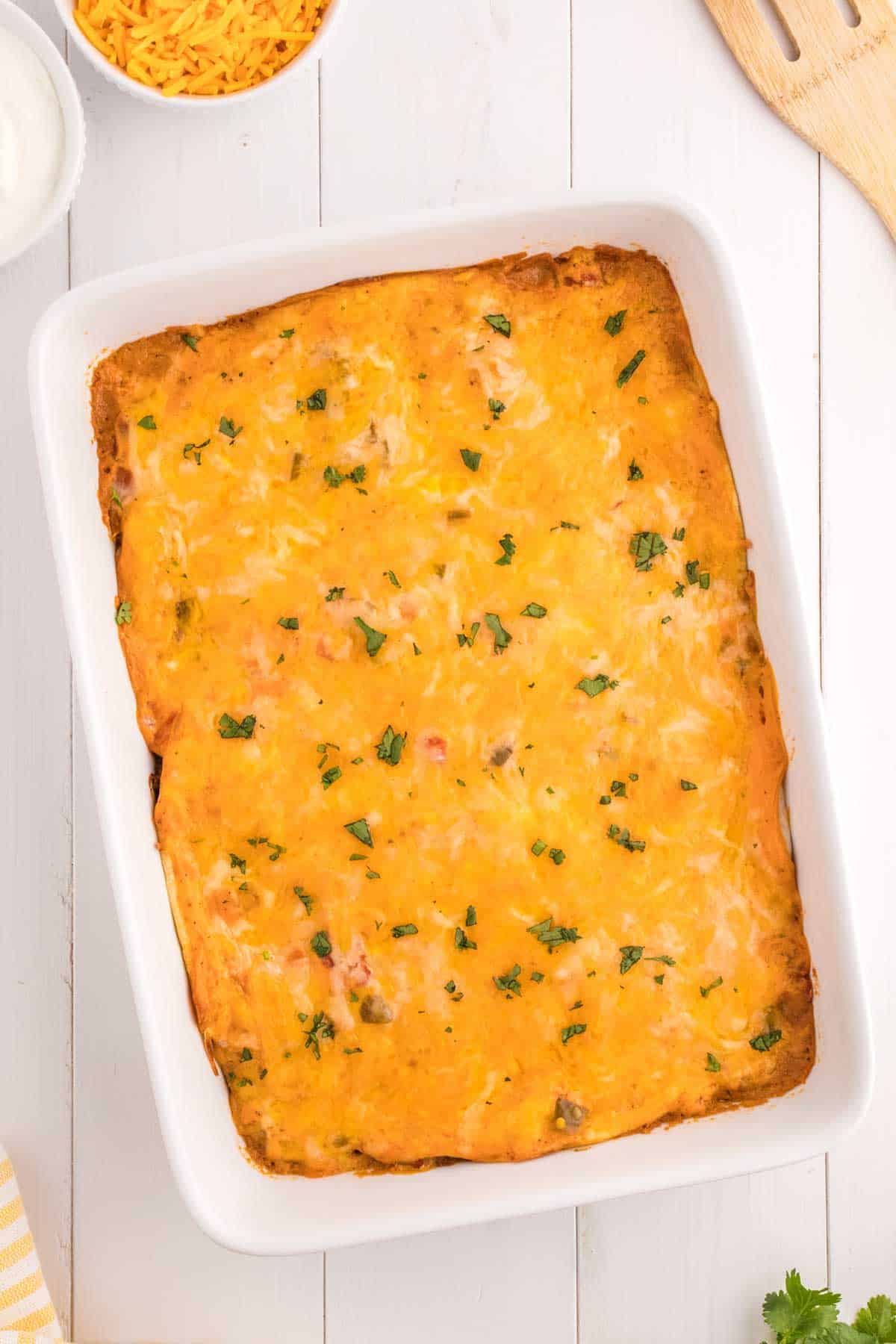 Creamy Burrito Casserole is a hearty dish loaded with flour tortillas, ground beef, refried beans, diced tomatoes, shredded cheese, salsa and sour cream.