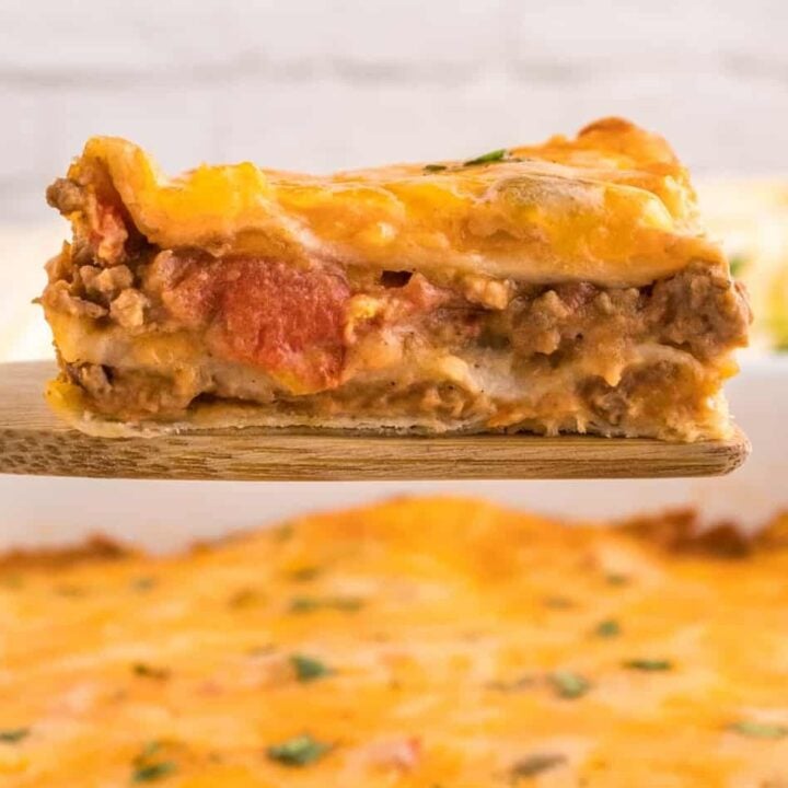 Creamy Burrito Casserole is a hearty dish loaded with flour tortillas, ground beef, refried beans, diced tomatoes, shredded cheese, salsa and sour cream.