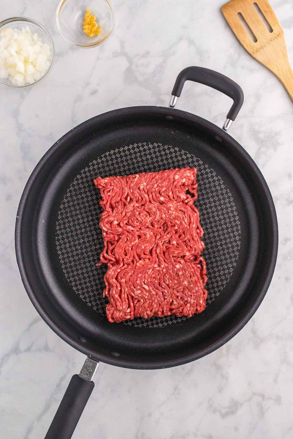 raw ground beef in a skillet