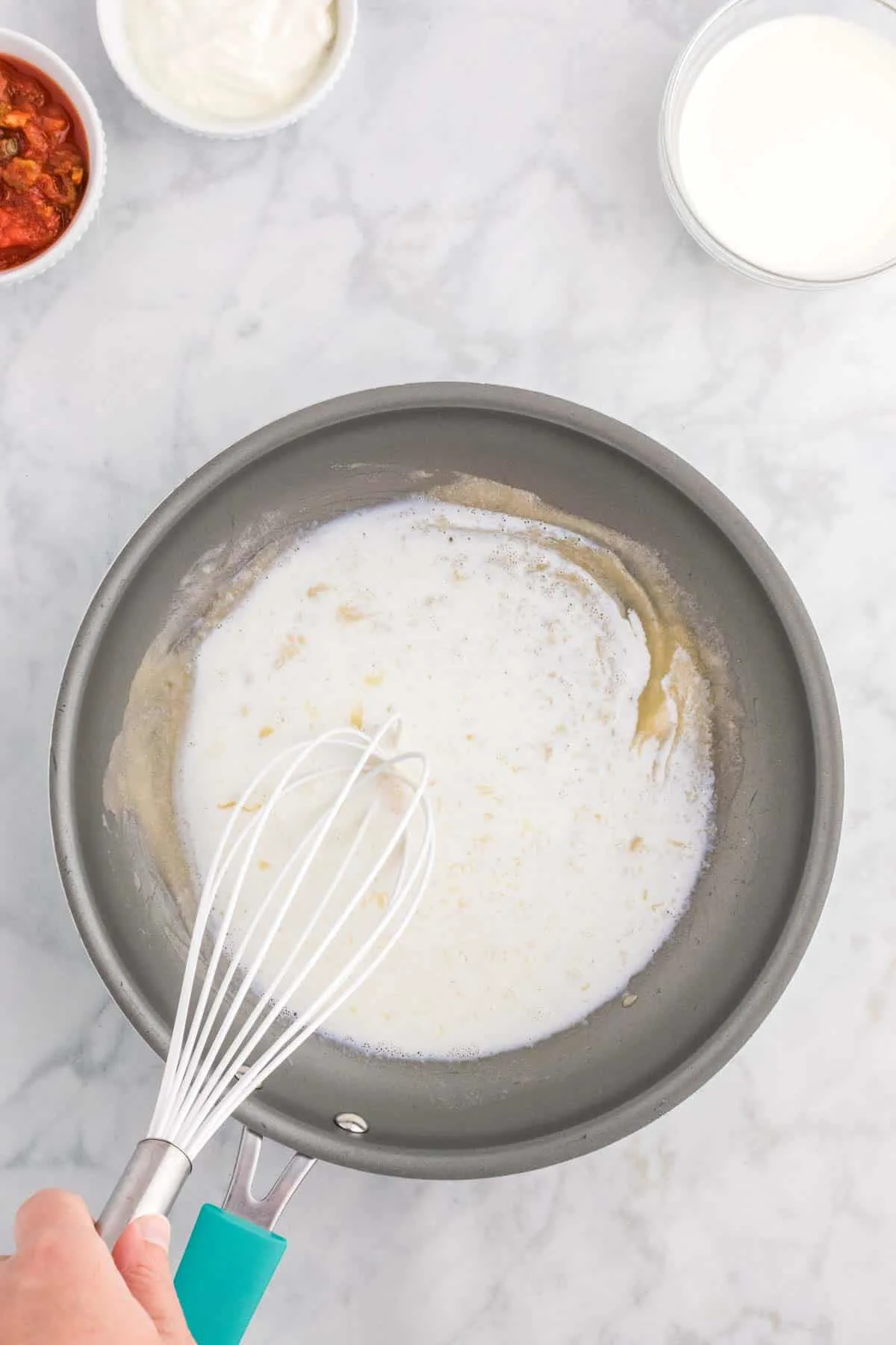milk, flour and butter mixture being whisked together in a saucepan
