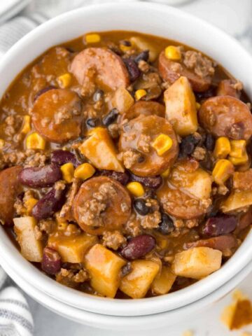 Texas Cowboy Stew is a hearty dish loaded with ground beef, smoked sausage, bacon, potatoes, corn, beans and diced tomatoes all in a flavourful beef broth.