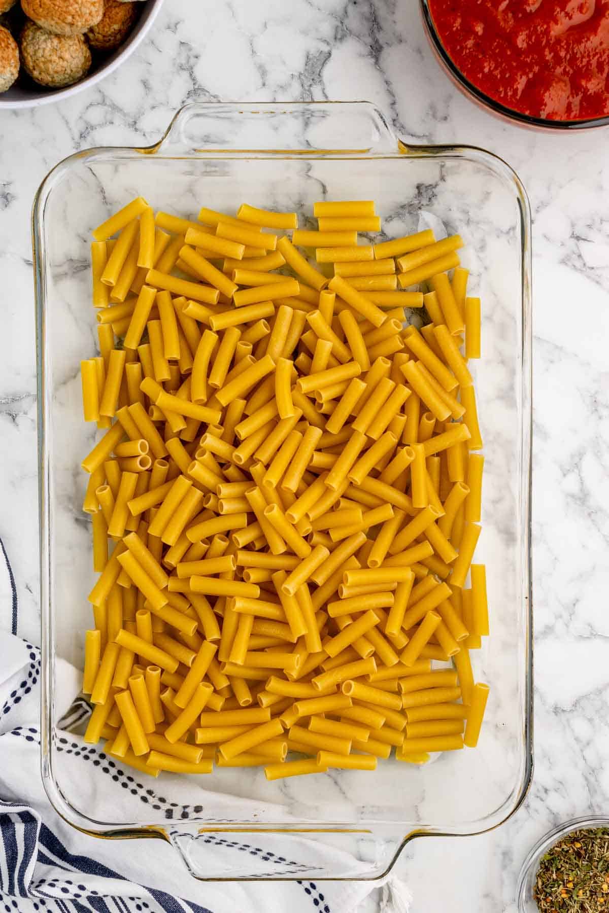 uncooked ziti noodles in a baking dish